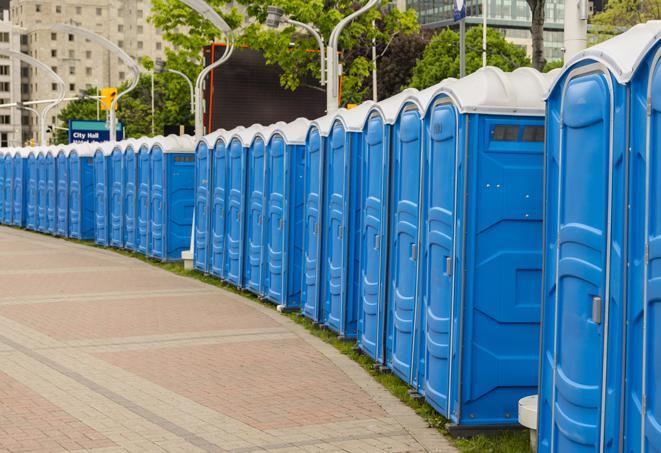 a line of portable restrooms at a sporting event, providing athletes and spectators with clean and accessible facilities in Amherst